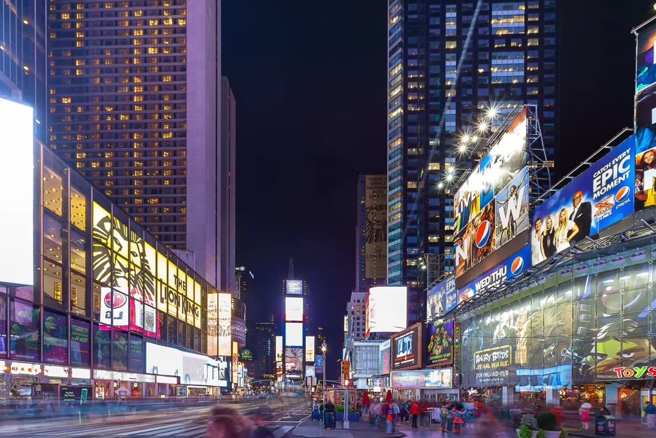 Times Square at night, lit by giant digital billboards